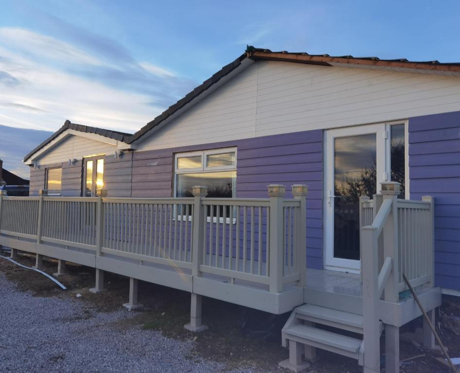 a purple house with a porch and a fence at 4-Bed Lodge in flamborough Bridlington sleeps 8 in Bridlington