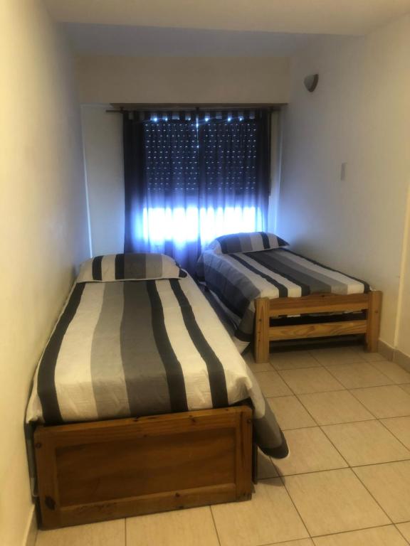 2 Betten in einem Zimmer mit Fenster in der Unterkunft Complejo Frente al Mar in Monte Hermoso