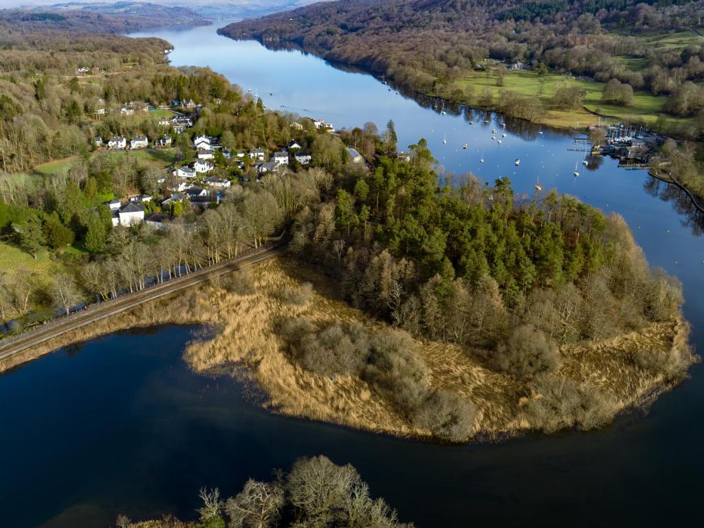an aerial view of a river with trees and houses at Lakeside View in Ulverston