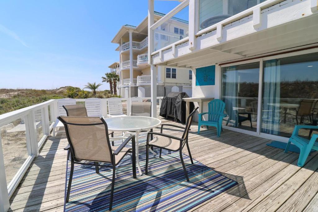 een terras met een tafel en stoelen bij #1 18th Street Lower in Tybee Island