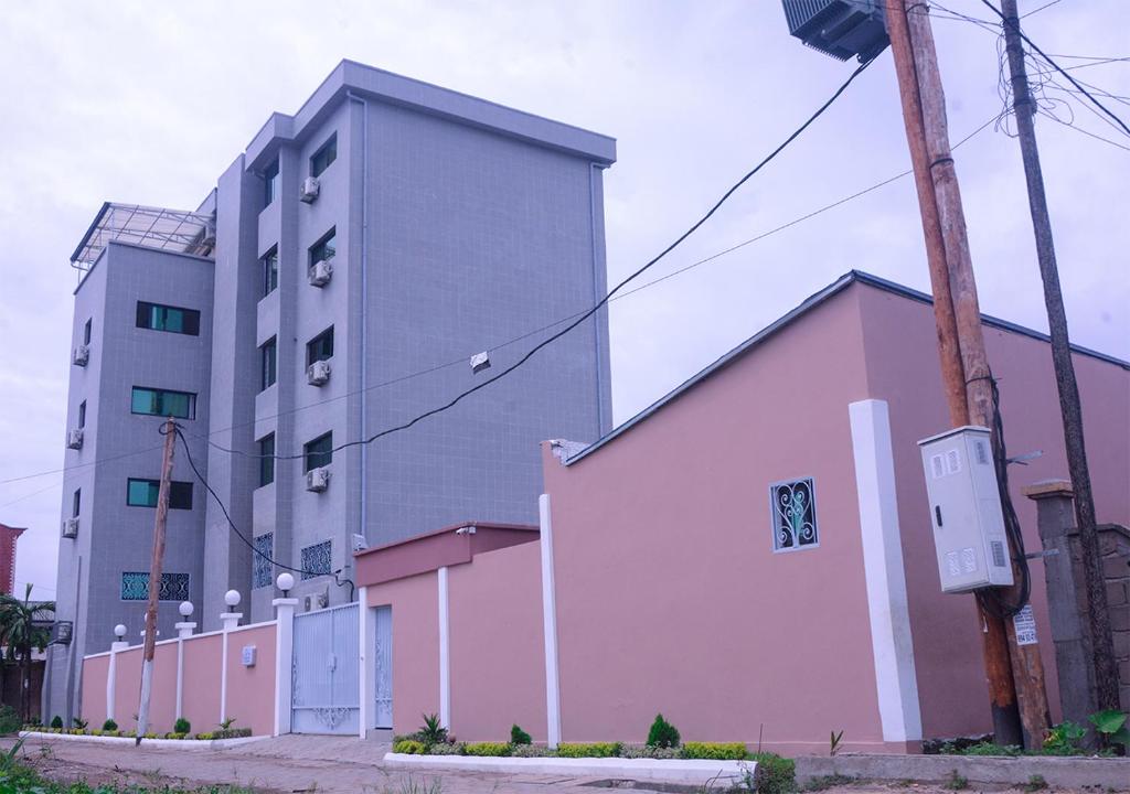un gran edificio junto a un edificio rosa en ORION RESIDENCY BONABERIE en Duala