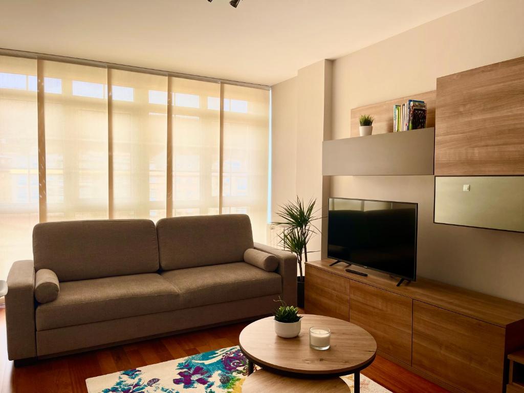 a living room with a couch and a television at Piso Vistas O Son in Cee