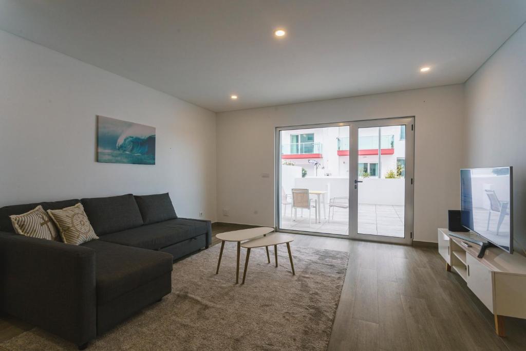 a living room with a couch and a tv at Best Houses 104 - Supertubos Beach Apartment in Atouguia da Baleia