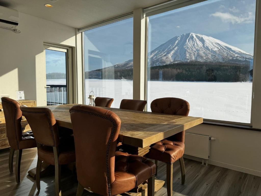 a dining room with a table and a mountain view at Mountain Villa ニセコ in Kutchan