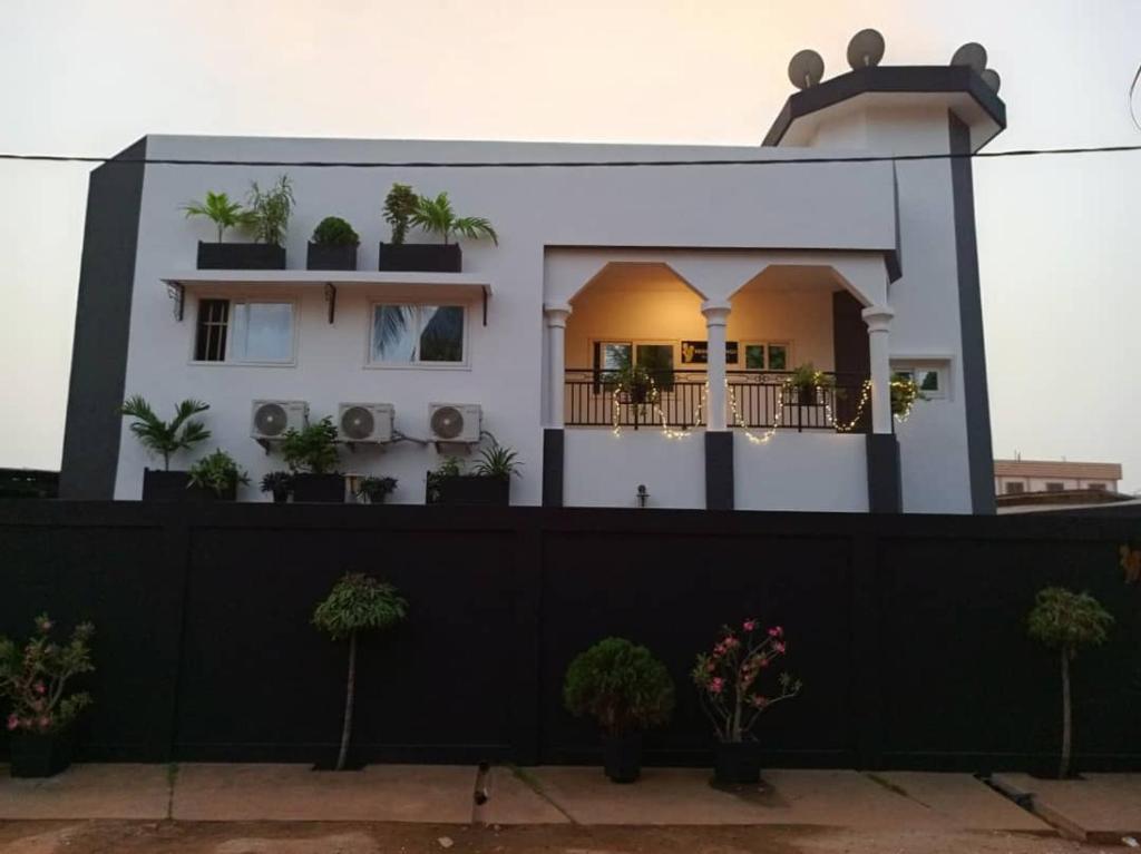 een huis met een zwart hek ervoor bij RESIDENCE MGA HOTEL in Ouidah