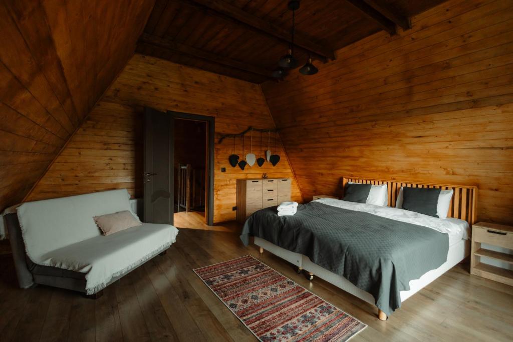 a bedroom with a bed and a chair in a room at Twin Cabins / Cabanele Gemene in Suceava