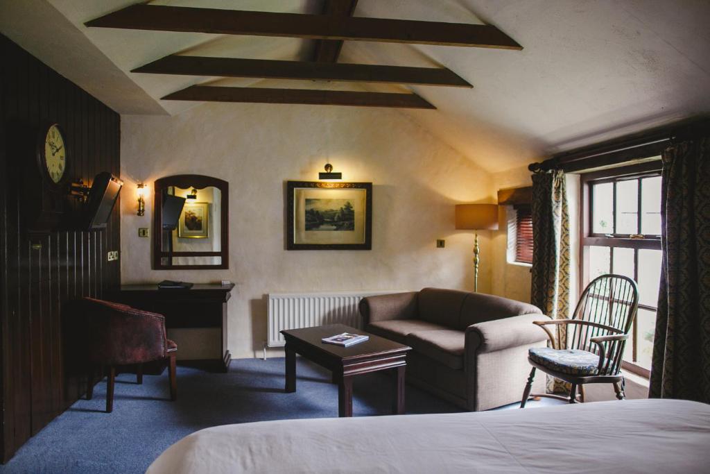 a bedroom with a bed and a couch and a table at Bushmills Inn Hotel & Restaurant in Bushmills