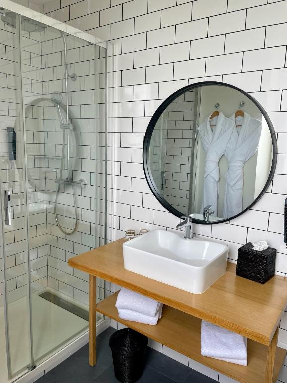 a bathroom with a sink and a mirror at Hôtel Les Costans, The Originals Relais in Perros-Guirec