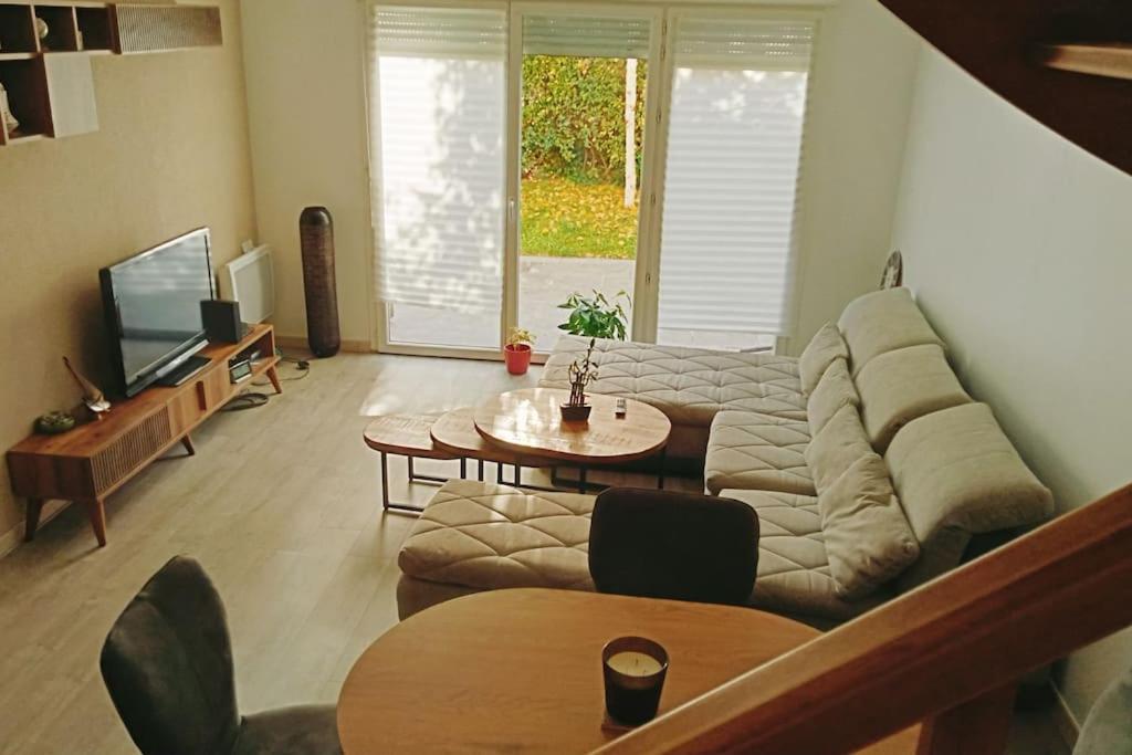 un salon avec un canapé et une table dans l'établissement Les Villas Terrasses (close Stade de France) idéal JO, à Saint-Denis