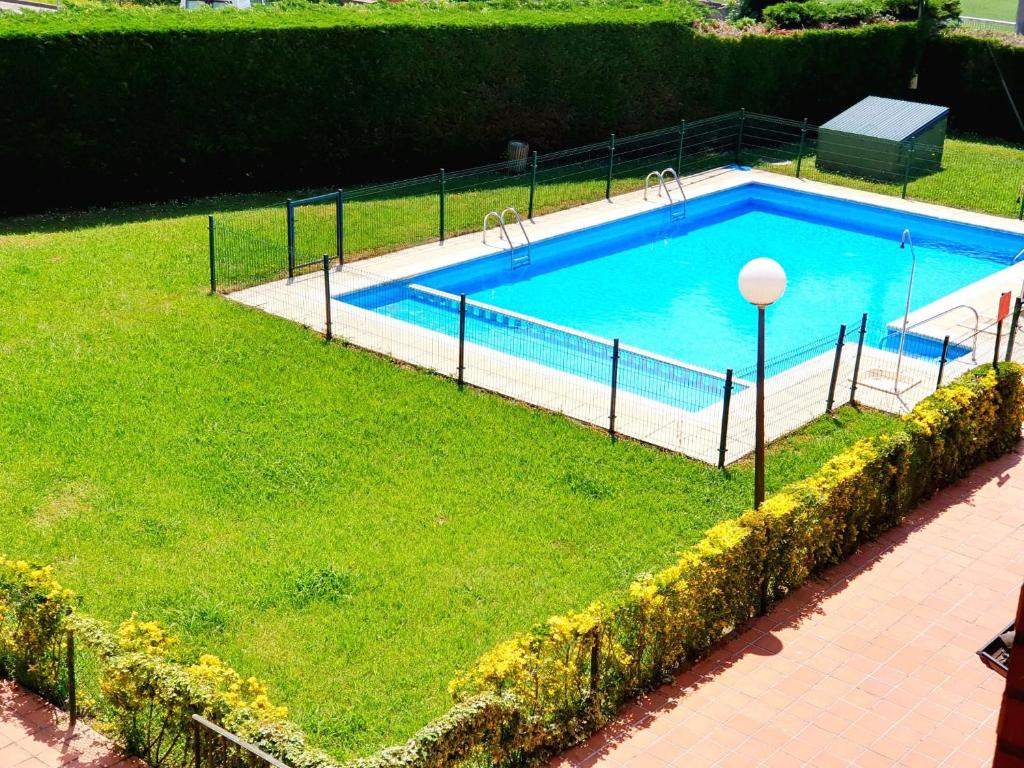 una gran piscina en un patio con césped en Bonito bajo con jardín, en Bárcena de Cicero