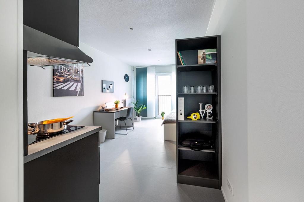 een keuken met zwarte kasten en een witte vloer bij Apartments Skyreach-WohnZimmer in Essen