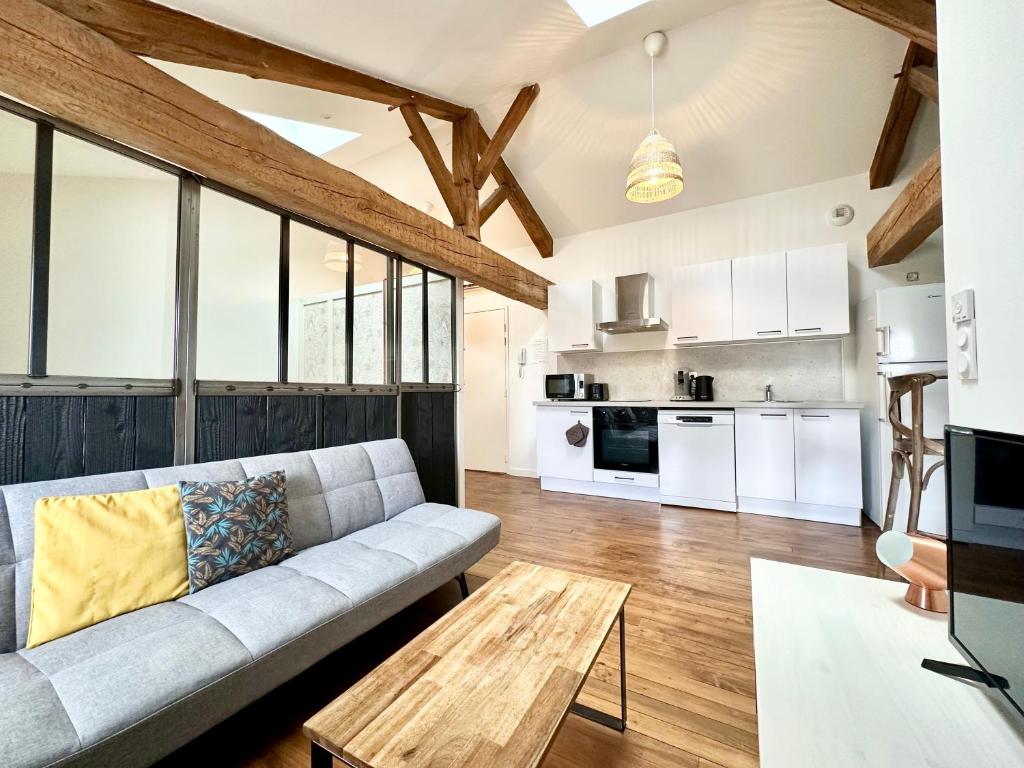 a living room with a couch and a table at LE PETIT LANDAIS - Chaleureux in Mont-de-Marsan