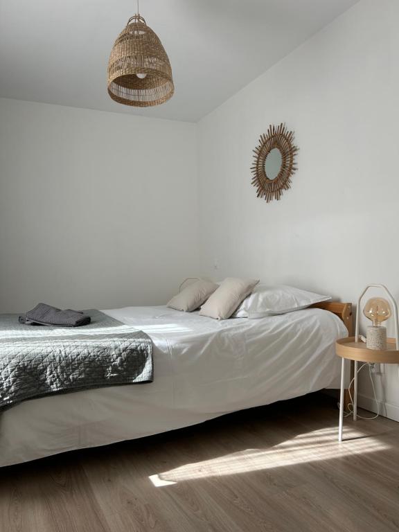 a white bedroom with a bed and a mirror at La terrasse : Appartement chic 2 chambres au coeur de Pau in Pau