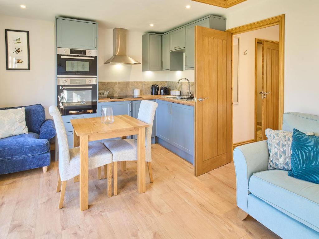 una cucina e un soggiorno con tavolo e divano di Host & Stay - Cobnut Barn ad Ashford