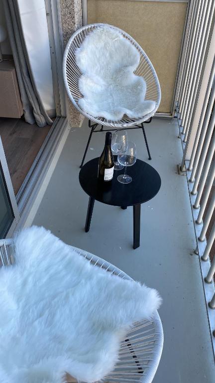 a chair and a table with wine glasses on it at Luxe appartement `t Sant Nieuwpoort Bad in Nieuwpoort