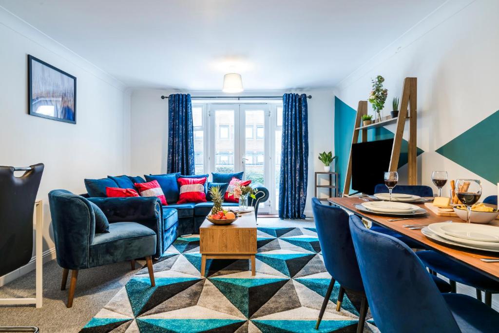 een woonkamer met een blauwe bank en een tafel bij InSpires House Contractors, families, Wifi, Free Parking Town Centre in Hemel Hempstead