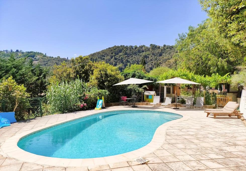 een zwembad in een tuin met een patio bij Un brin de paille in Cagnes-sur-Mer