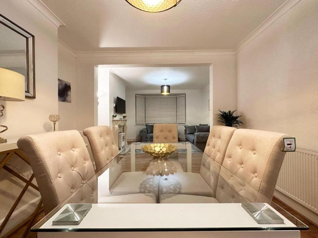sala de estar con mesa de cristal y sillas en Charming 3-bedroom family home en Londres