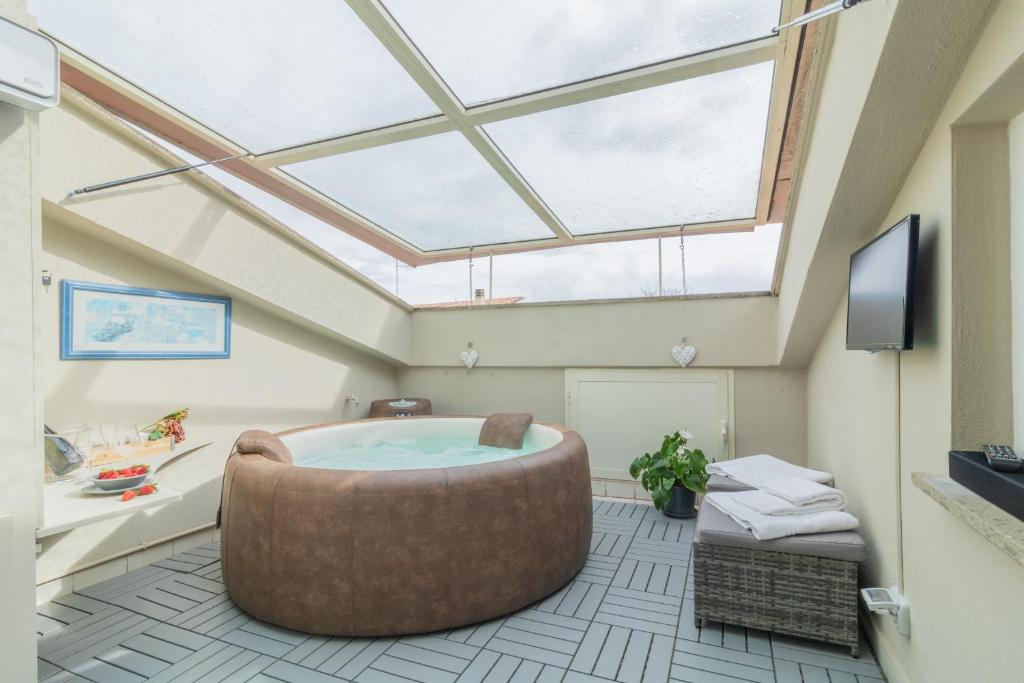 um quarto com uma grande banheira de imersão e uma clarabóia em Sweet Home Lilli em Ronciglione