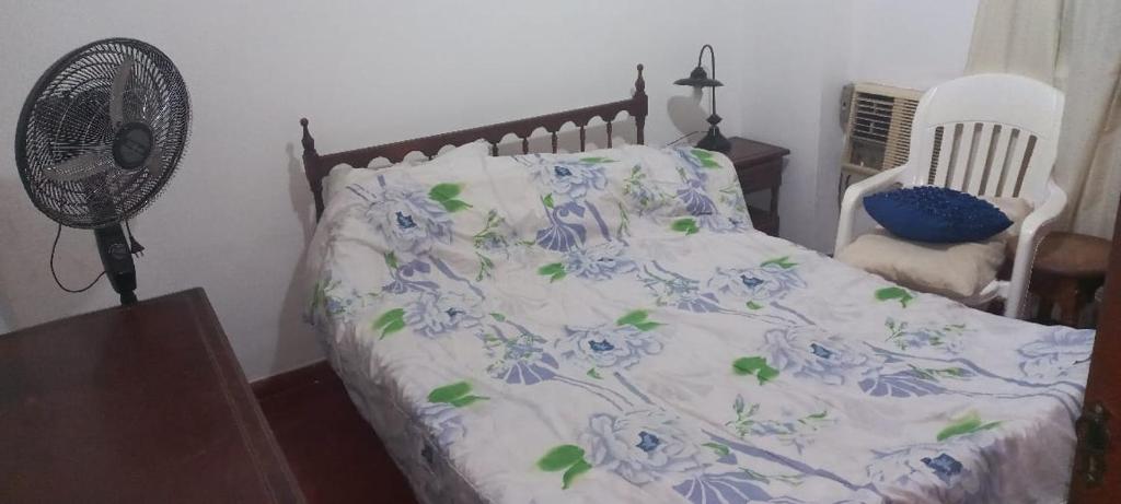 1 dormitorio con 1 cama con flores azules y ventilador en Departamento centrico frente a costanera en Posadas