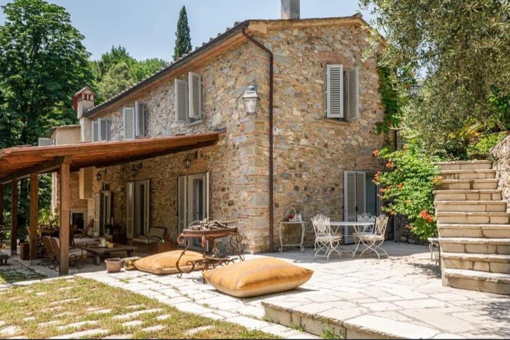 una casa de piedra con un patio frente a ella en Villa mulino del 500, en Carmignano