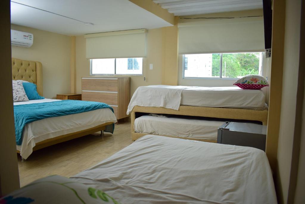 a room with three beds and two windows at Cabañas covemar in Coveñas