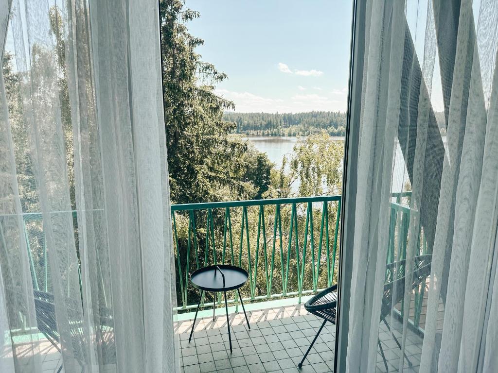 a balcony with a table and a view of a lake at Hotel Medlov in Nové Město na Moravě