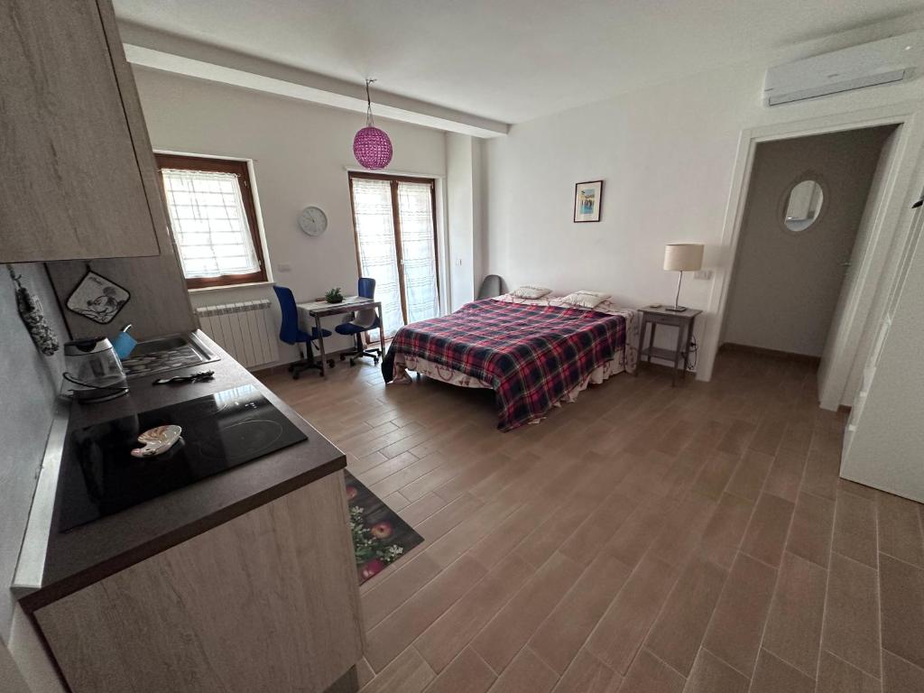 a bedroom with a bed and a kitchen with a table at Monolocale Mezzocammino in Mostacciano
