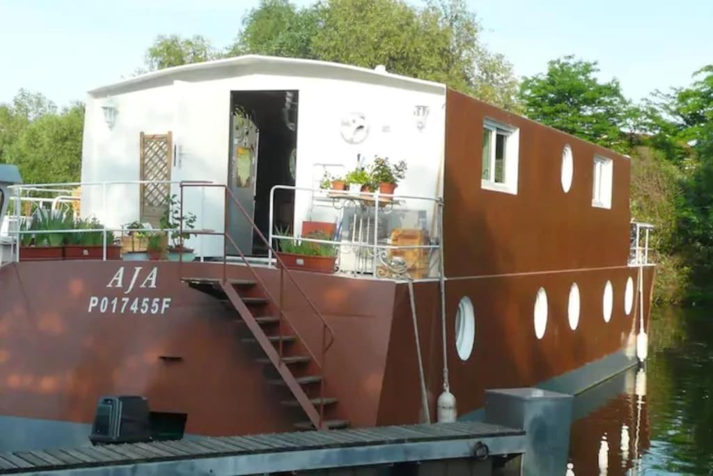 un grand bateau est amarré dans l'eau dans l'établissement House boat AJA, à Vigneux-sur-Seine