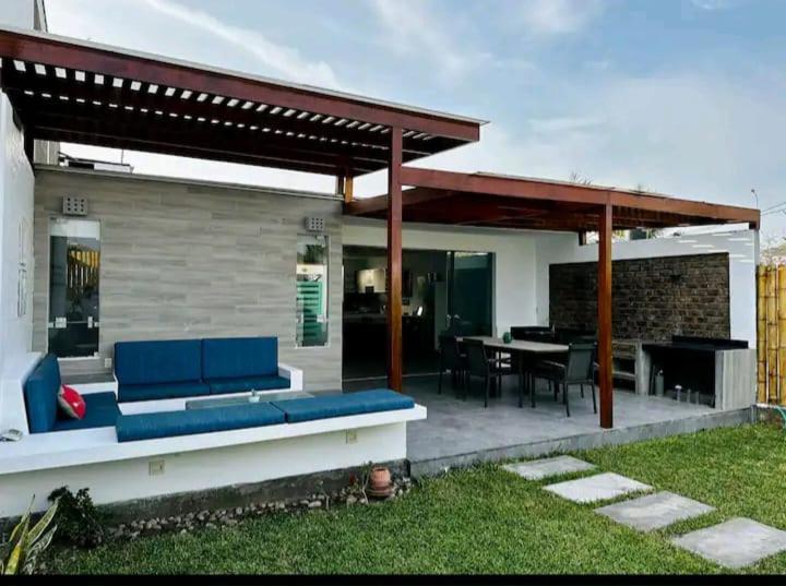 un patio cubierto con un sofá azul y una mesa en Alquilo casa de playa en Chocaya- La Venturosa, en Asia