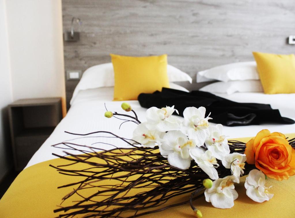 un ramo de flores blancas y naranjas en una cama en Sole Hotel Verona, en Verona