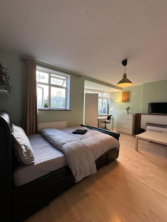 a bedroom with a large bed and a living room at Whitechapel Rooms R3 in London