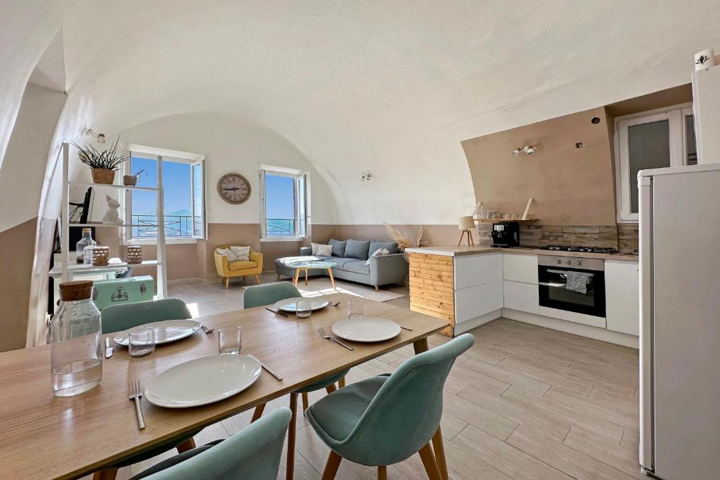 a kitchen and living room with a wooden table and chairs at Les Terrasses du Château I Electio in Lauris