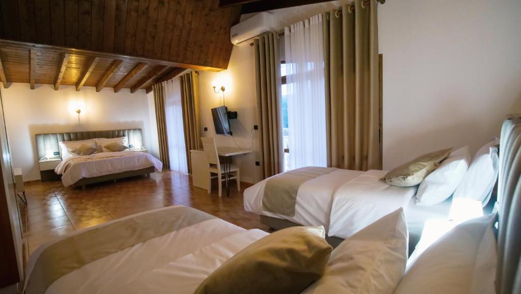 a hotel room with two beds and a television at Vila Malasi in Berat