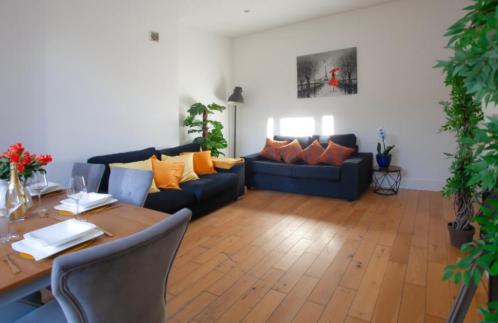 a living room with a table and a blue couch at Templar Apartment in London