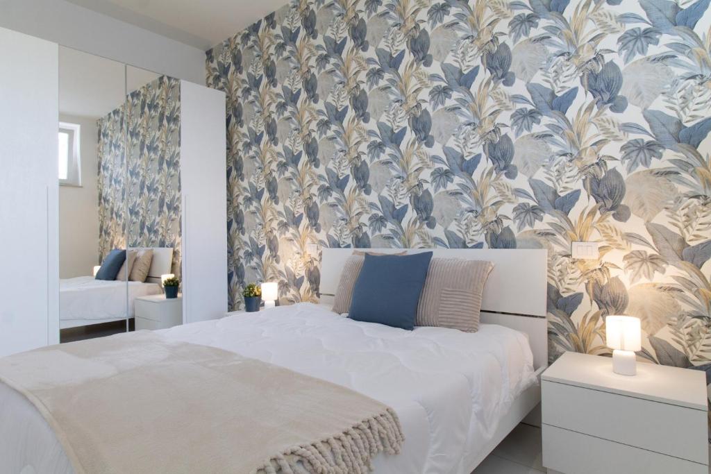 a bedroom with a bed with a blue and gold wallpaper at Sky Suite Blue Pomezia in Pomezia