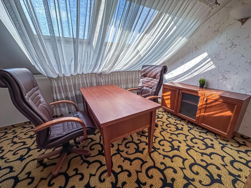 All-in rooms في فيلنيوس: مكتب فيه مكتب و كرسيين و طاولة