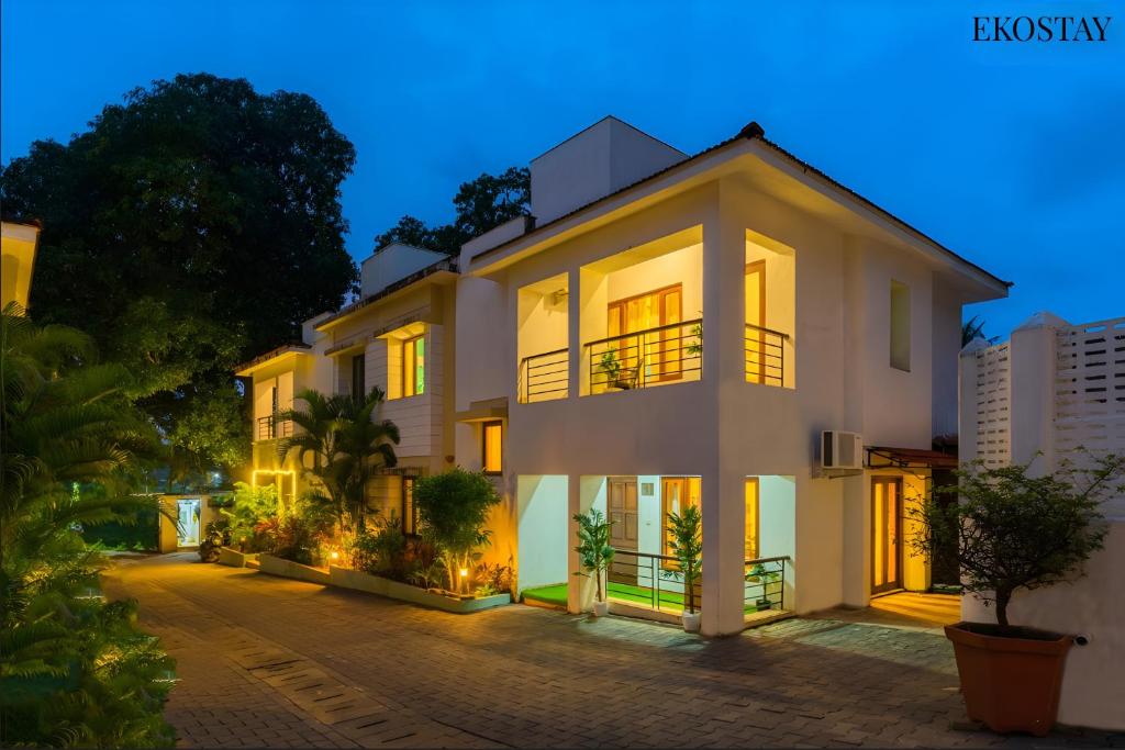 una gran casa blanca con sus luces encendidas en EKO STAY - Solace Villa I Charming Villa close to Candolim Beach en Marmagao