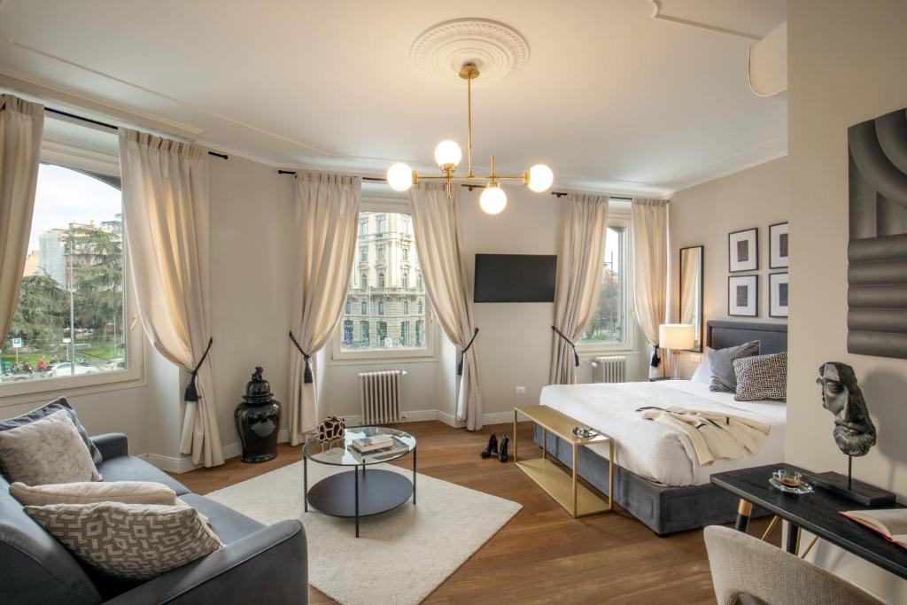 a bedroom with a king sized bed and a couch at Daplace - Corso Monforte Suites in Milan
