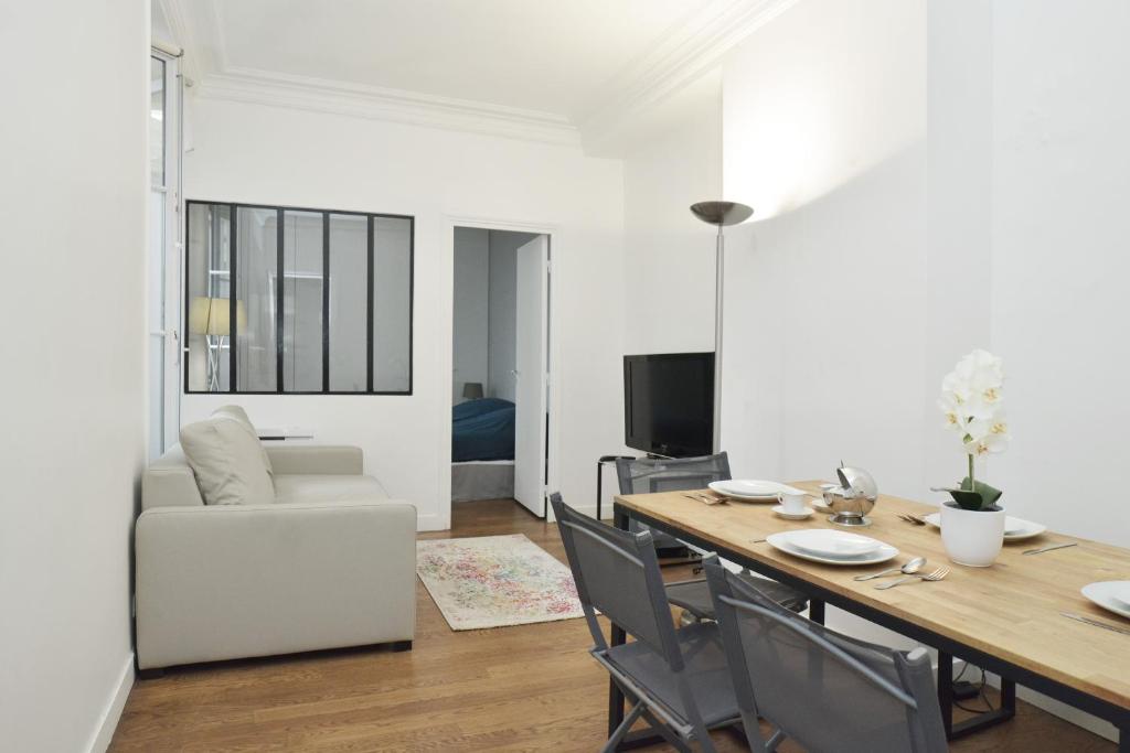 une salle à manger et un salon avec une table et des chaises dans l'établissement -Votre nid familial parisien - Batignolles, à Paris