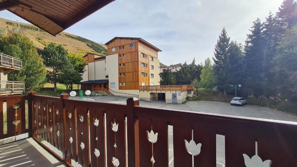 un balcon avec un bâtiment et un parking dans l'établissement Alpina Lodge - 12 - Appart spacieux - 8 pers, à Les Deux Alpes