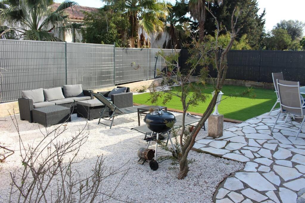 une cour arrière avec un barbecue et un foyer dans l'établissement Villa au calme / Clim / Barbecue / Parking /Plage, à Fréjus