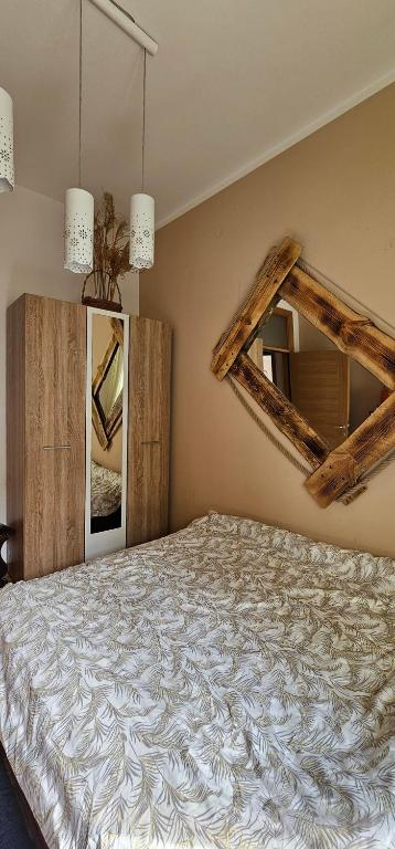 a bedroom with a large bed and a mirror at Apartman Kalina in Novi Sad