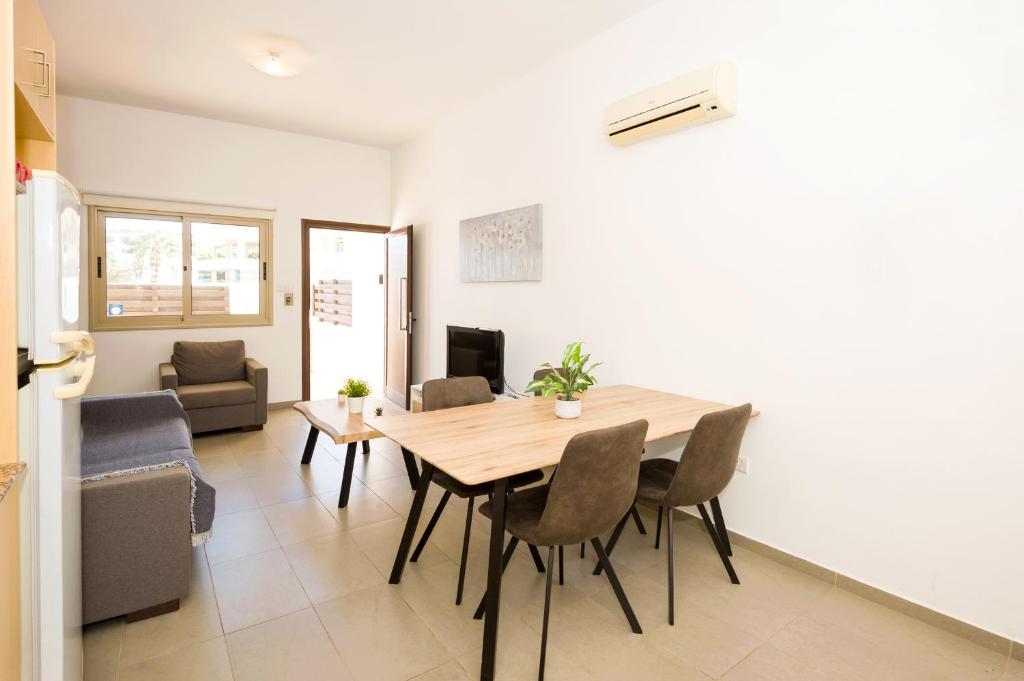 a kitchen and dining room with a table and chairs at Bowker Apartment in Protaras