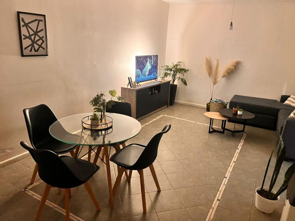 - un salon avec une table, des chaises et un canapé dans l'établissement Cómodo Departamento en Godoy Cruz, à Godoy Cruz