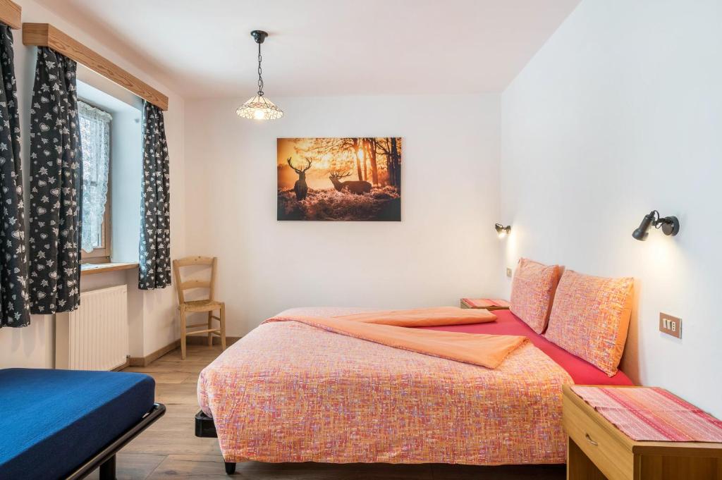 1 dormitorio con cama, mesa y ventana en Agriturismo El Cirum Boe, en Livinallongo del Col di Lana