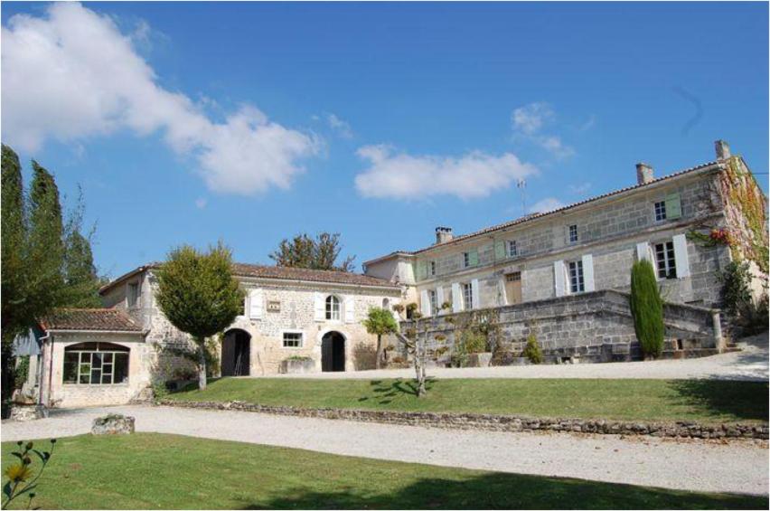 Moulidars的住宿－Domaine borgnette fantastique maison，一座大型石头建筑,前面有一个院子