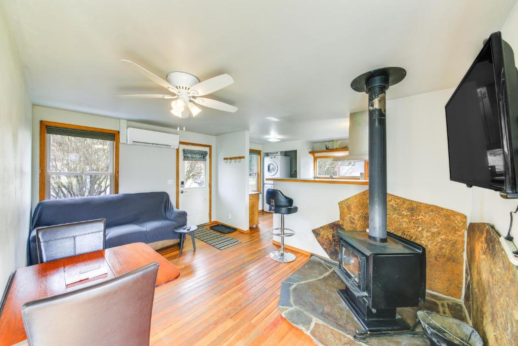 a living room with a fireplace and a tv at Clark Fork Vacation Home with Wood Stove Near Lake! in Clark Fork