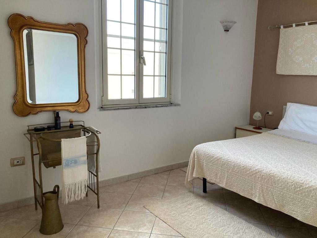 a bedroom with a bed and a mirror on the wall at S'imbustHouse in Oristano