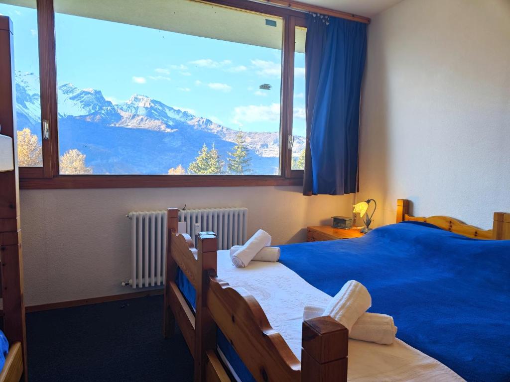 1 dormitorio con ventana grande con vistas a la montaña en Hostdomus - Sansicario R8, en San Sicario